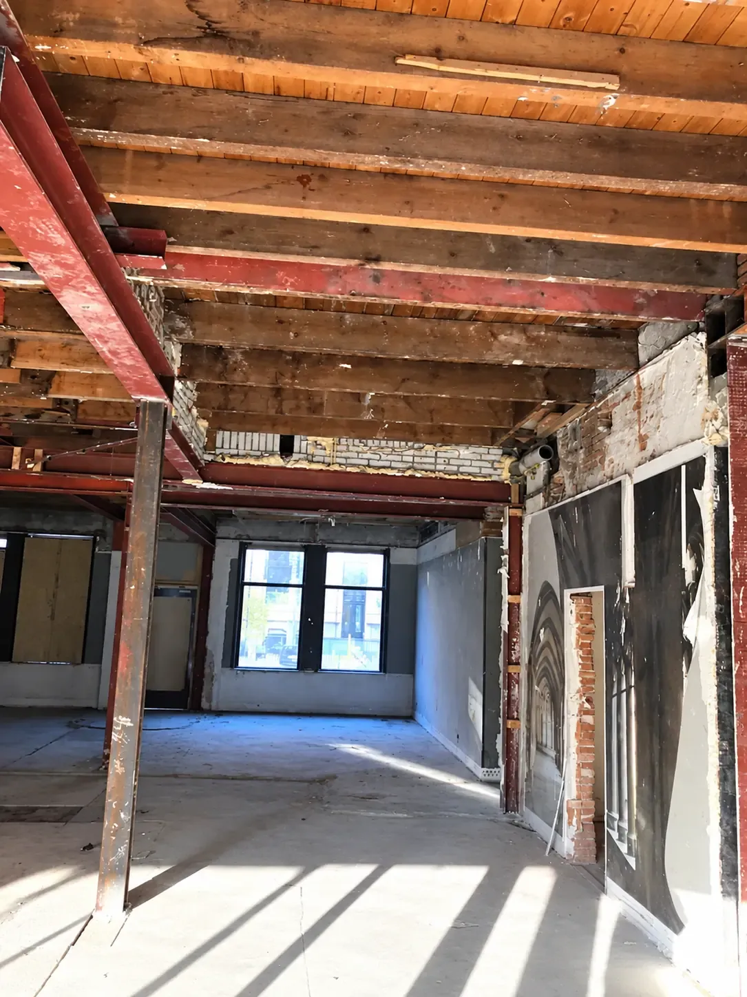Een gestript interieur met vrijgelegde houten plafondbalken.